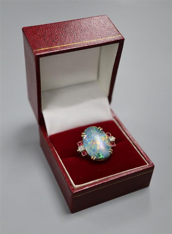 A 1930s/1940s yellow metal, oval black opal, ruby and diamond set dress ring, size O/P, gross 6.8 grams,